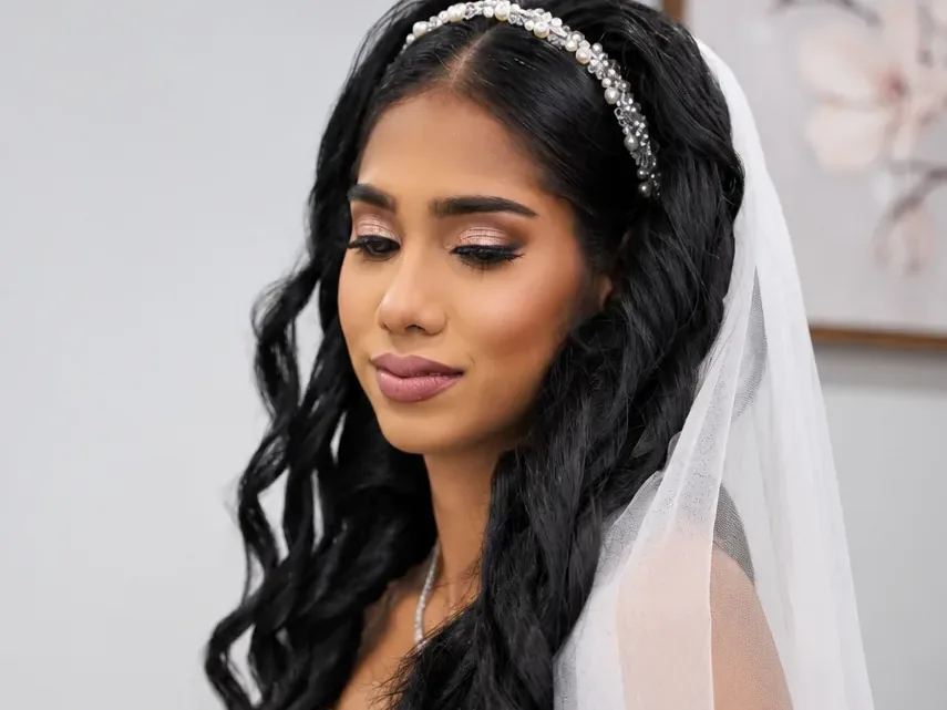 Bride with veil and bouquet after bridal hair and makeup